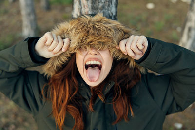 Laughing woman wearing fur hat standing outdoors