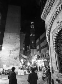 People on illuminated building at night