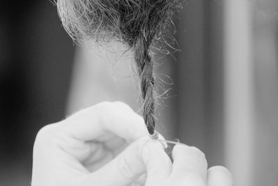 Cropped hands of woman holding braided hair