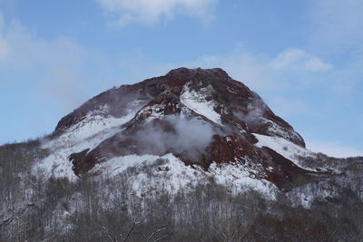 Low angle view of mountain against sky during winter