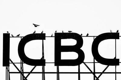 Low angle view of birds sign against sky