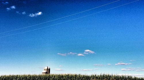 Low angle view of landscape against blue sky