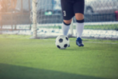 Low section of person playing soccer on field