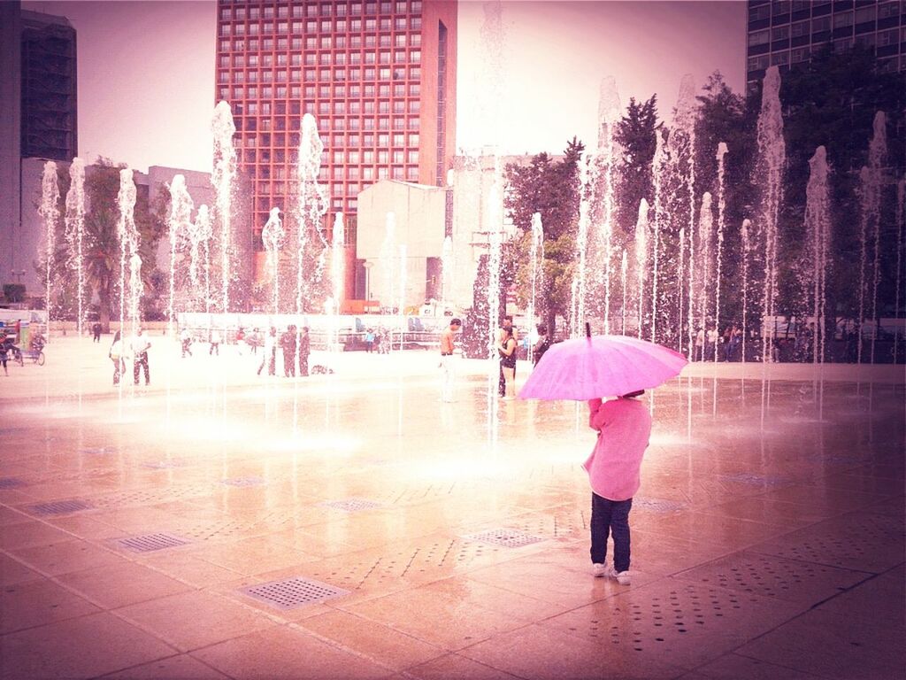 lifestyles, full length, leisure activity, walking, building exterior, casual clothing, built structure, umbrella, person, girls, architecture, rear view, standing, city, tree, childhood, city life, street
