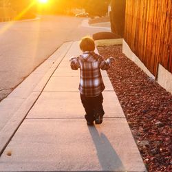 Rear view of boy on footpath