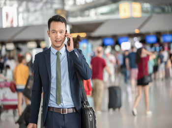 Portrait of smiling man standing at airport