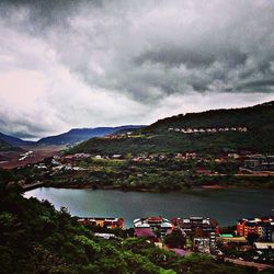 Scenic view of river and mountains against cloudy sky