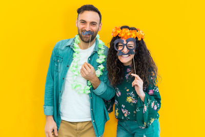 Portrait of smiling young man against yellow background