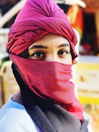 Close-up portrait of woman face covered with scarf