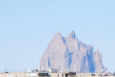 Houses by rock formation against clear sky