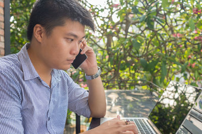 Businessman using laptop while sitting outdoors