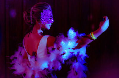 Midsection of woman dancing against blue sky at night