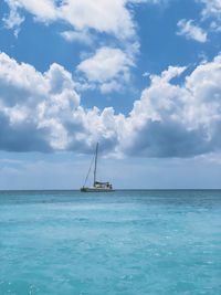 Sailboat sailing on sea against sky