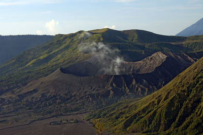 Smoke emitting from volcanic crater against sky