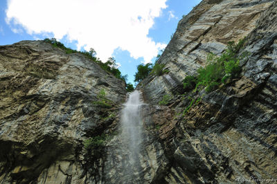Scenic view of waterfall against sky