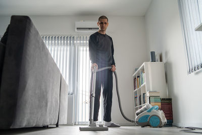 Portrait of young man standing at home