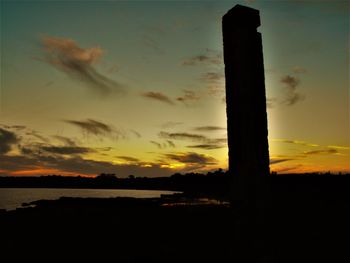 Silhouette built structure against sky during sunset