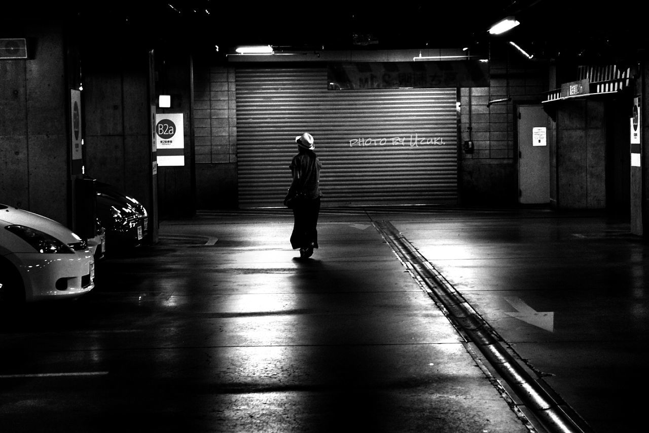 FULL LENGTH OF WOMAN WALKING ON ILLUMINATED ROAD