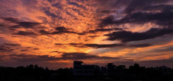 Silhouette buildings against sky during sunset