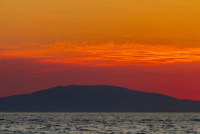 Scenic view of sea against romantic sky at sunset