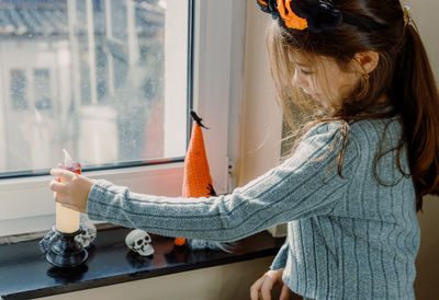 Rear view of woman with arms raised standing in bathroom