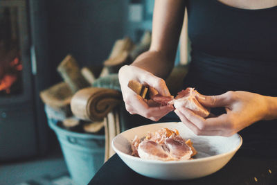 Midsection of woman holding ice cream on table