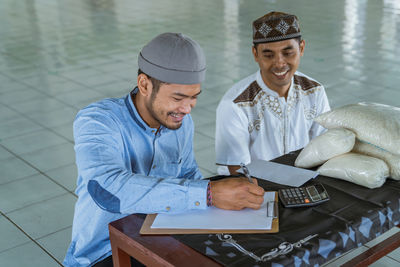 High angle view of men receiving rice bag at mosque