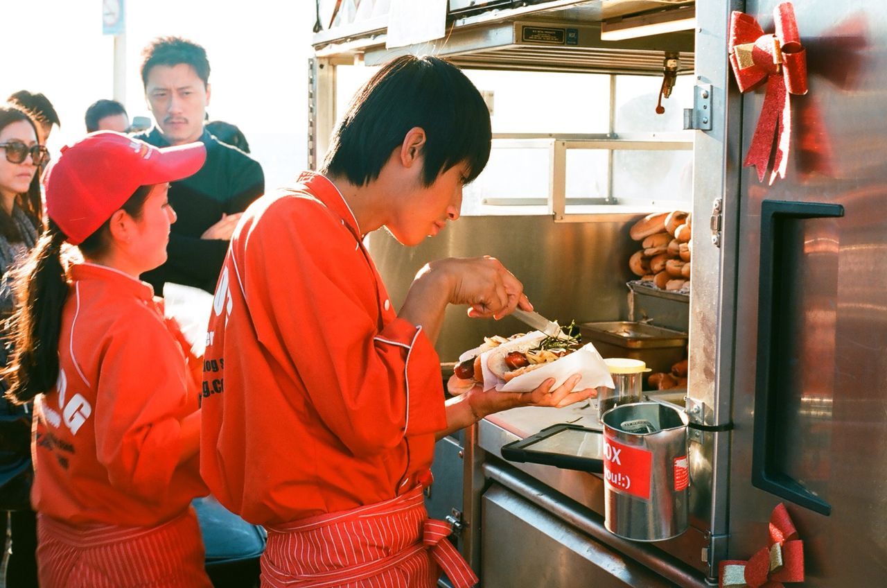 indoors, lifestyles, casual clothing, person, food and drink, leisure activity, young men, holding, sitting, front view, men, food, three quarter length, occupation, standing, happiness, togetherness