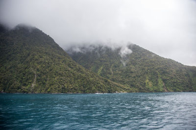 Scenic view of sea and mountains against sky