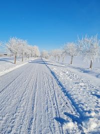 Snow covered field against blue sky