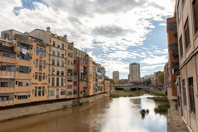 Canal amidst buildings in city, , girona spain