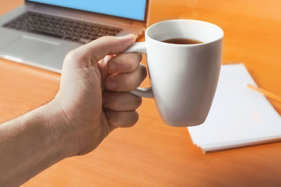 Midsection of coffee cup on table