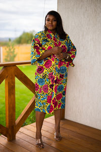 Portrait of young woman standing against wall