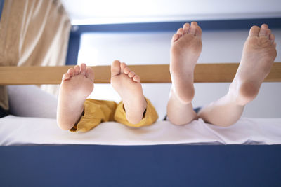 Low section of woman sitting on bed