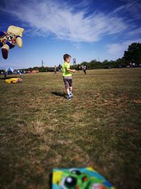 Man playing with ball on field against sky