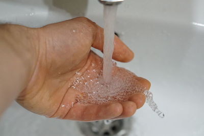 Close-up of person holding hands in bathroom