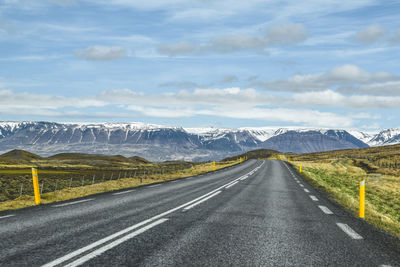 Country road against cloudy sky