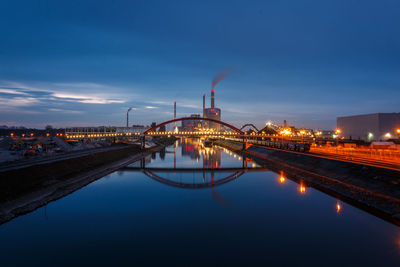 Illuminated bridge over river against sky at night