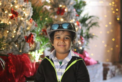 Portrait of smiling boy against christmas tree
