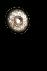 Close-up of illuminated electric lamp in darkroom