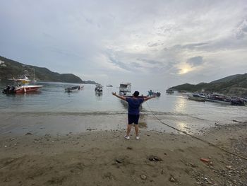 Rear view of man photographing sea against sky