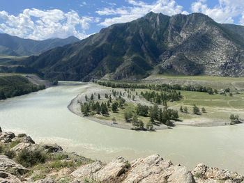 Scenic view of river amidst mountains against sky