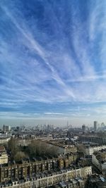 High angle view of city buildings against cloudy sky