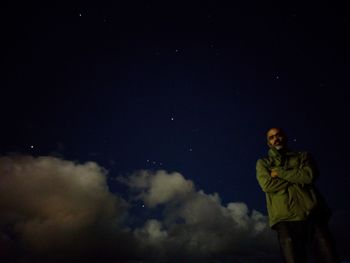 Portrait of man standing against sky at night