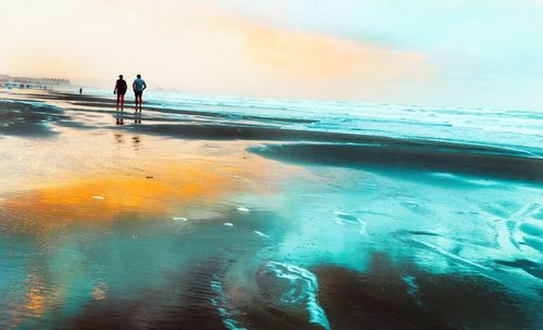 People on beach against sky