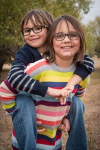 Portrait of smiling siblings at park