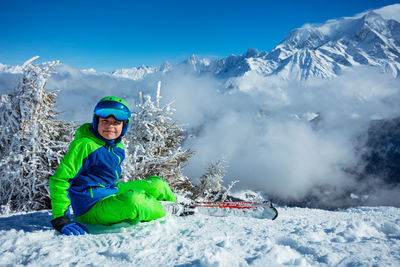 Portrait of man sitting on snow