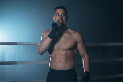 Portrait of young man exercising against sky