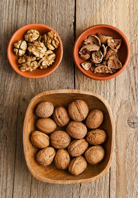 High angle view of nuts in bowls on wooden table