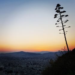 Scenic view of silhouette mountains against orange sky